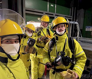 Four people in yellow fire protectant suits.