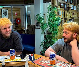 Two men with newly dyed blonde hair sharing a drink.