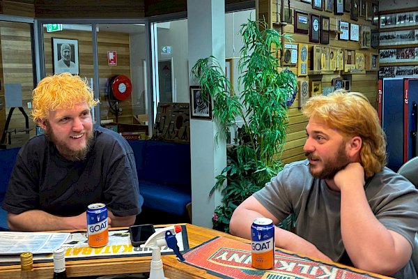 Two men with newly dyed blonde hair sharing a drink.