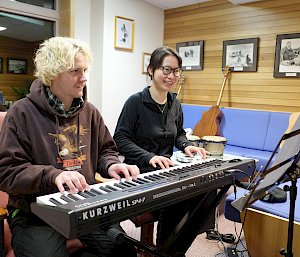 Two expeditioners sittings at a keyboard