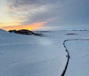 The sun low on the horizon over the snow and ice
