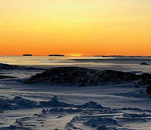 A sunset over snow and ice