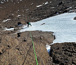 An expeditioner ice climbing on a mountain in Antarctica