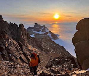 An expeditioner climbing a mountain in Antarctica