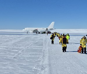 Expeditioners leave the plane on the ice runway