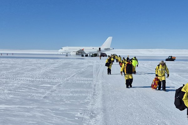 Expeditioners leave the plane on the ice runway
