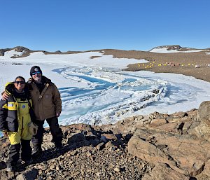Two expeditioners standing next to each other with ice and ocean in the background