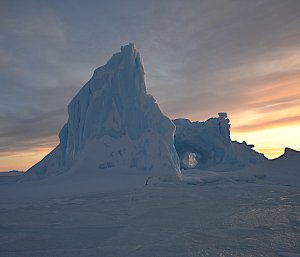 Iceberg in foreground with sunrise in background