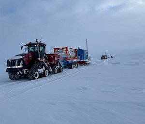 Quadtrac tractor towing a sled with the cargo