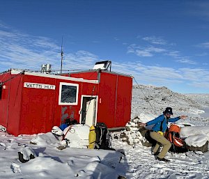 man looking excited in front of field hut