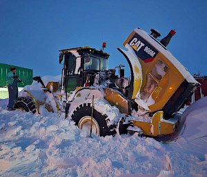 man digging out snow from loader