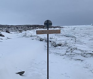 pipe and sign near frozen antarctic waters