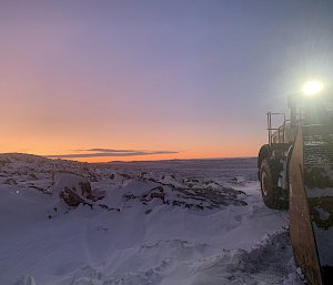 sunrise with loader in foreground