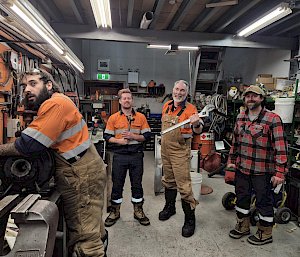 The plumbing workshop with 4 expeditioners and one holding a giant spanner