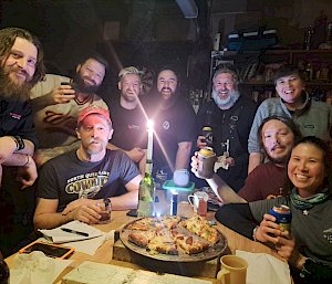 Expeditioners around the dinner table at a hut