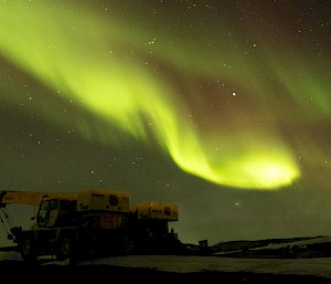The night sky with auroras and machinery in the foreground in Antarctica