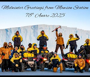 Group photo of the Mawson team on the sea ice, arranged around four quad vehicles