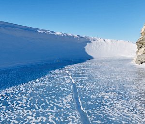 Photograph taken close at a low angle to some ice next to rocks on the right