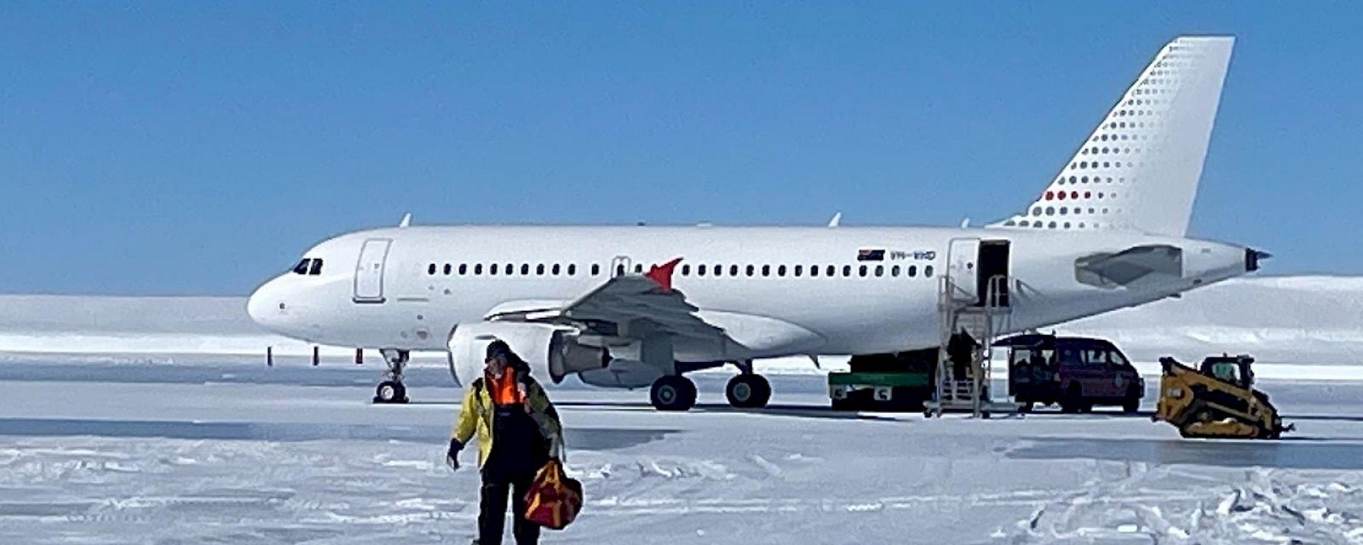 Expeditioner walking off plane parked on the ice
