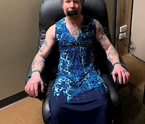 man wearing a dress tied to a chair