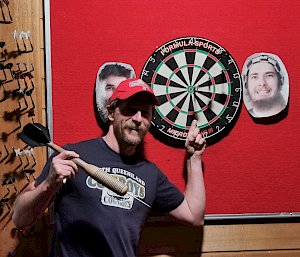 An expeditioner standing in front of the dart board