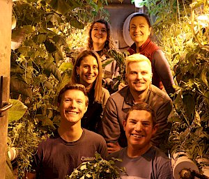 Six expeditioners inside the hydroponics shed.