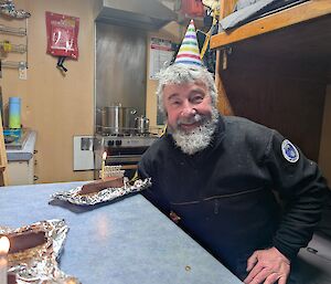 An expeditioner with a party hat inside the accommodation van celebrating his birthday