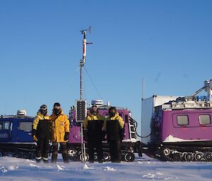 The team standing in front of their vehicles and the AWS having completed their work