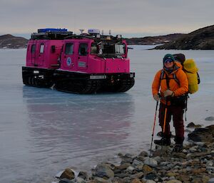 person standing on sea ice next to vehicle