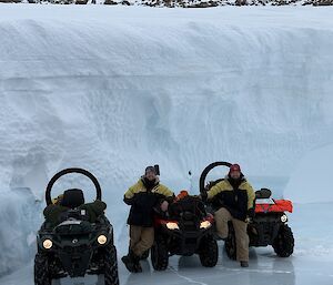 two men with three trusty Can-Am vehicles in front of an ice wall