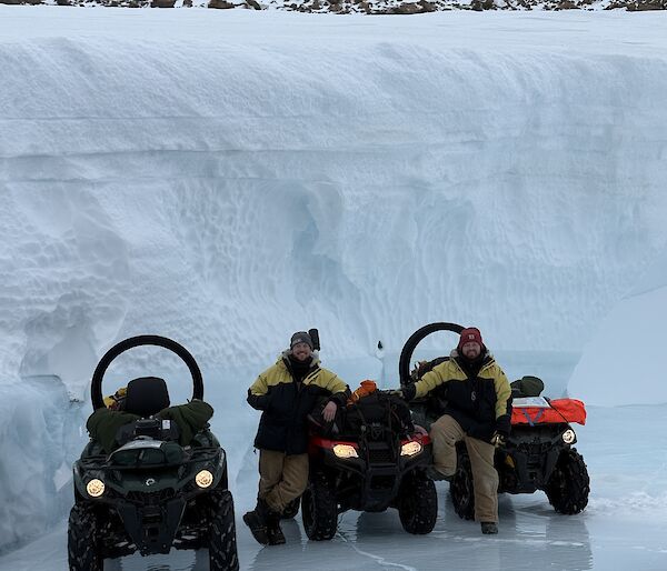 two men with three trusty Can-Am vehicles in front of an ice wall