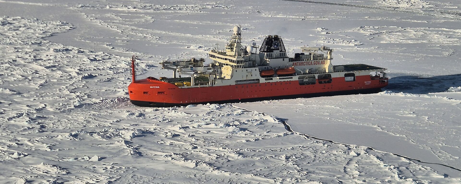 Red icebreaker parked in ice