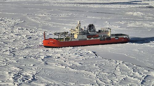 Red icebreaker parked in ice