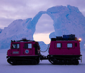A twin cab Hagglund vehicle parked on ice in front of iceberg