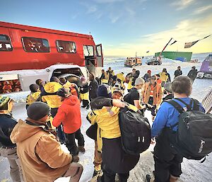 A large group of people farewelling each other as some leave Casey station to get a bus to Wilkins Aerodrome