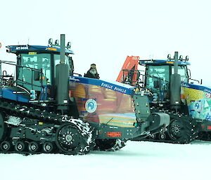 2 tractors and one expeditioner parked on the ice