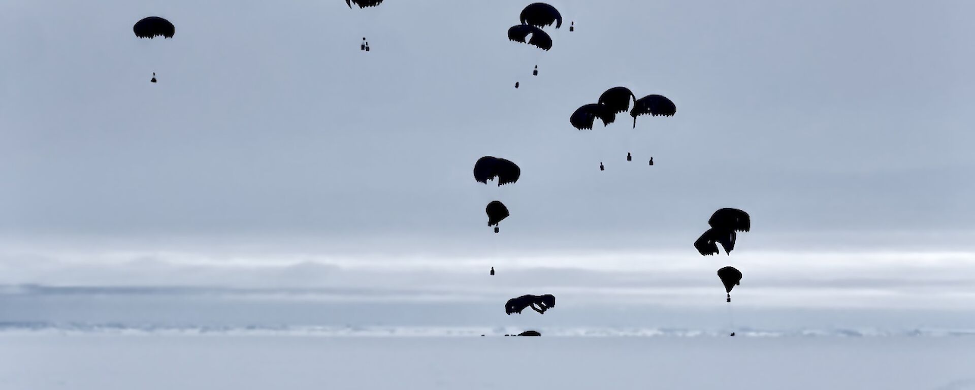Parachutes falling from the sky onto the ice