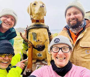 Four smiling people pose with Stay, the collection Guide Dog