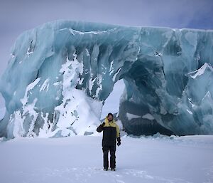 A man standing in front of a huge jade iceberg