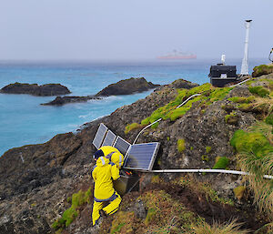 People on the side of a hill working on solar panels