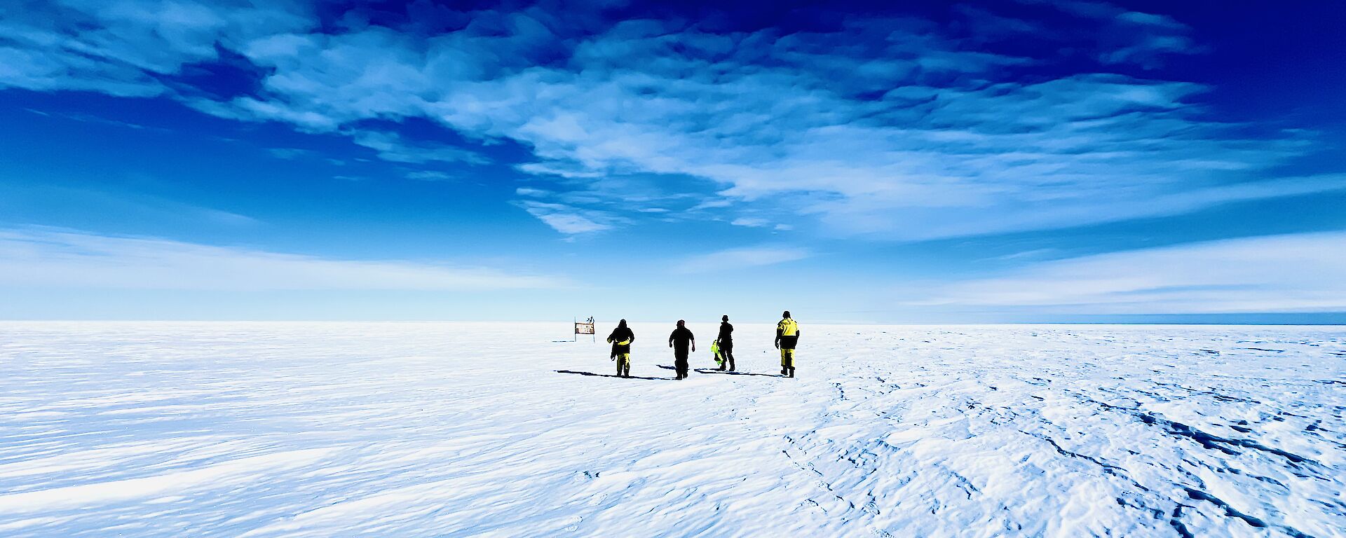 Expeditioners walking across the ice and snow