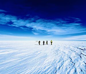 Expeditioners walking across the ice and snow