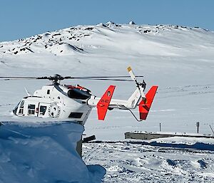 The landed helicopter with snow-capped mountain in the background