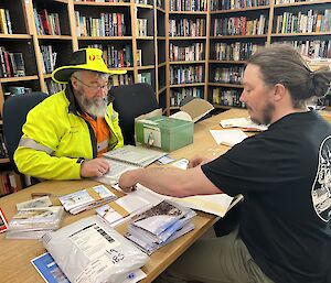 Postmaster and a customer sitting at the desk