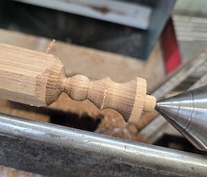 An almost completed pawn made from Huon Pine sits in the lathe