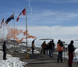 people on hill holding flares