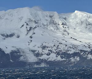 Choppy seas with snow-covered mountains behind