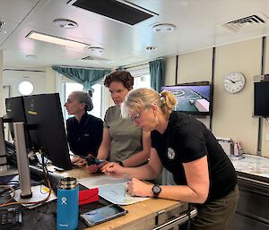 Three women in a lab looking at computer screens