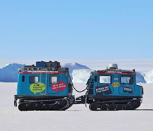 A blue, twin-cab Hagglund vehicle on sea ice
