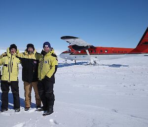 Three men stand in front of a Twin Otter aircraft on the Mawson skiway